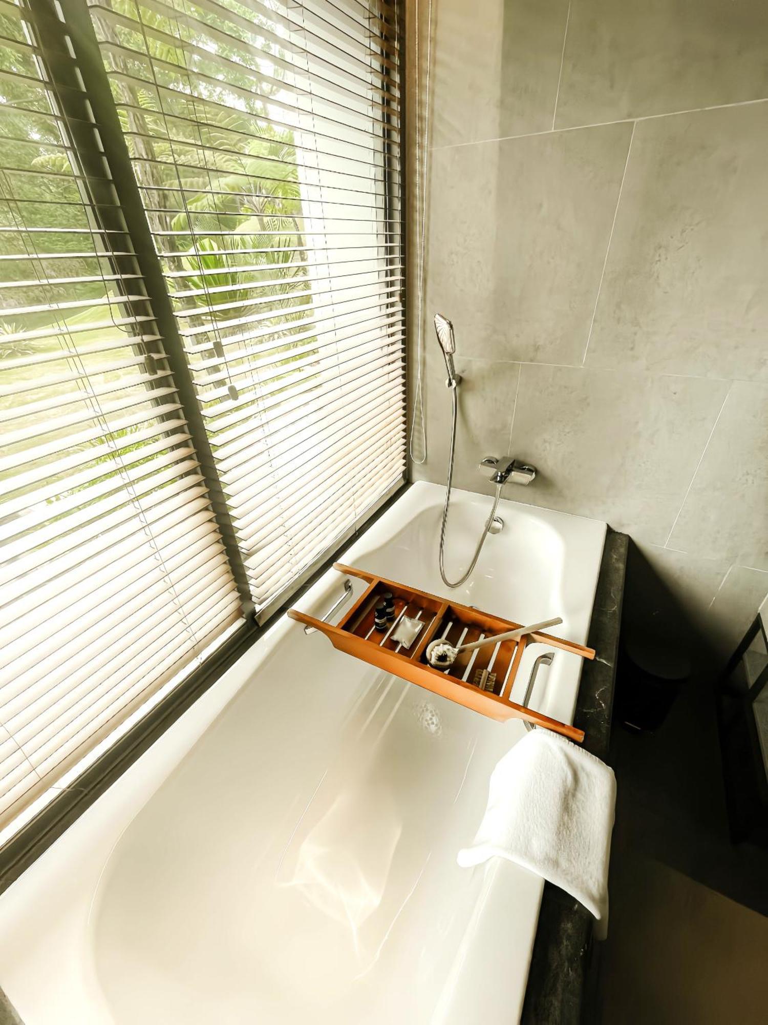 The Botanica Sanctuary Hotel Puncak Room photo A bathtub with a shower